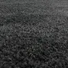 A close-up view of a dark gray shaggy rug. Produktbild-Vorschau