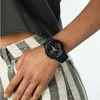 A person wearing a watch on their wrist, with their hand in their pocket. Voir les images du produit