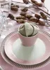 A table setting with plates, a napkin in a bowl, and decorative branches. Produktbild-Vorschau