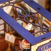 A close-up view of a miniature tea shop, part of a 3D puzzle kit, showing intricate details of the interior and exterior. Produktbild-Vorschau