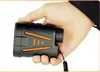 A hand holding a black and orange laser rangefinder. Produktbild-Vorschau