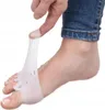 A person's finger is shown stretching a clear gel toe separator onto a foot. Podgląd zdjęcia produktu