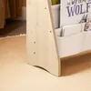 A close-up view of the bottom part of a wooden bookshelf with fabric pockets holding books and notebooks. Produktbild-Vorschau