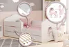 A child's bed with unicorn and ballerina illustrations, featuring close-up details of the mattress and slatted base. Produktbild-Vorschau