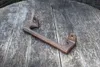 A cast iron handle resting on a wooden surface. Produktbild-Vorschau