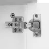 A close-up view of a cabinet hinge attached to a white surface. Náhled obrázku produktu