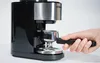 A hand holding the portafilter of an espresso machine. Anteprima dell’immagine prodotto