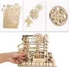 A collage of images showing a wooden marble run construction kit, including unassembled parts, close-ups of gears, and a partially assembled model being operated by a hand. Voir les images du produit