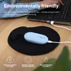 A light blue wireless mouse and its charging cable are placed on a black mousepad on a wooden desk, with a laptop in the background. Produktbild-Vorschau