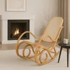 A rocking chair is placed in front of a fireplace in a living room. Voir les images du produit