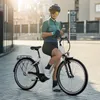 A woman in cycling gear is posing with her e-bike on a city street. Produktbild-Vorschau