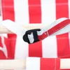 A close-up of a red and white striped fabric with a wooden dowel and a black buckle attached by a white strap. Produktbild-Vorschau
