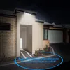 A solar wall light illuminates the entrance of a modern house at night. Produktbild-Vorschau
