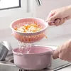 A person is rinsing shredded vegetables in a pink colander over a pink bowl in a kitchen sink. Náhľad obrázku produktu
