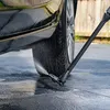 A pressure washer wand is spraying water on the tire and lower body of a black car parked on a tiled surface. Náhľad obrázku produktu