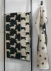 Two towels with a dachshund pattern are displayed on a towel rack, and another towel with a paw print pattern is hanging on a hook. Anteprima dell’immagine prodotto