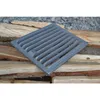A cast iron grate rests on a pile of firewood. Voir les images du produit