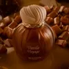 A perfume bottle surrounded by caramel candies. Voir les images du produit
