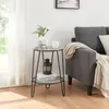 A small round side table with two shelves is placed next to a gray sofa in a living room. Anteprima dell’immagine prodotto
