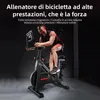 A man is riding a stationary exercise bike in a dark room with studio lighting. Anteprima dell’immagine prodotto