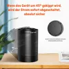 A black cylindrical heater is shown on a wooden surface, with an illustration indicating its tilt safety feature. Produktbild-Vorschau
