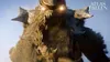A large, imposing creature made of sand and rock, with glowing eyes, stands against a bright sky. Náhled obrázku produktu