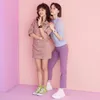 Two young women posing against a pink and purple background, wearing casual outfits and watches. Anteprima dell’immagine prodotto
