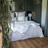 A bedroom scene with a bed made up with white bedding. Produktbild-Vorschau