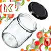 A glass jar and its lid are shown with various vegetables and herbs arranged around them, suggesting ingredients for preserving. Anteprima dell’immagine prodotto