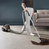 A person is vacuuming a carpet with a Rowenta vacuum cleaner. Produktbild-Vorschau