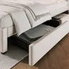 A close-up view of a beige upholstered bed frame with drawers open, revealing storage space with folded gray blankets inside. Anteprima dell’immagine prodotto