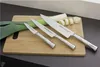 Three knives and a leek on a wooden cutting board. Podgląd zdjęcia produktu