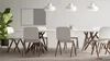 A modern dining or meeting room setting with a white table and chairs, a large plant, and a two-panel board on the wall. Produktbild-Vorschau