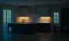 A dimly lit modern kitchen with under-cabinet lighting illuminating the backsplash and island. Podgląd zdjęcia produktu
