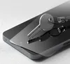 A silver key rests on a clear screen protector placed on a dark smartphone. Produktbild-Vorschau