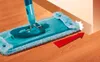 A spray mop cleaning a wooden floor next to a wall. Produktbild-Vorschau