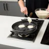 A person is making pancakes in a special pan on a gas stove. Produktbild-Vorschau