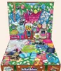 A festive, open advent calendar filled with various candies and small novelty items, arranged like a Christmas scene. Produktbild-Vorschau