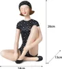 A figurine of a woman in a vintage swimsuit and swim cap, sitting with her legs crossed. Anteprima dell’immagine prodotto