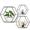 Three hexagonal wall shelves with decorative items on a white background. Produktbild-Vorschau