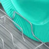 A close-up shot of a turquoise plate sitting in a gray dish rack. Produktbild-Vorschau