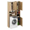 A washing machine is placed under a tall cabinet with multiple shelves and doors, filled with various items. Náhled obrázku produktu