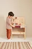 A young boy is playing with a wooden toy workbench. Produktbild-Vorschau