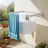 A wall-mounted retractable clothes dryer on a balcony with laundry hanging on it. Anteprima dell’immagine prodotto