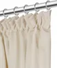 A close-up view of cream-colored curtains hanging from a silver curtain rod. Náhled obrázku produktu