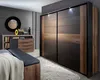 A bedroom scene featuring a modern wardrobe, dresser, and bench. Produktbild-Vorschau