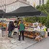 People at an outdoor market stall with a black canopy tent. Voir les images du produit