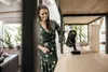 A woman is using a cordless vacuum cleaner on a wooden shelf. Produktbild-Vorschau