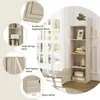 A tall, narrow bookshelf with four shelves and one door, placed next to a window with sheer curtains. The bookshelf is light oak colored and decorated with a framed picture, a hat, and decorative figurines. The image also includes close-up insets highlight Produktbild-Vorschau