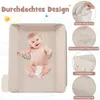 A baby is shown on a beige changing table with various features highlighted by text overlays. Produktbild-Vorschau